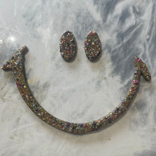 Large gold glitter and sequin eyes and mouth.