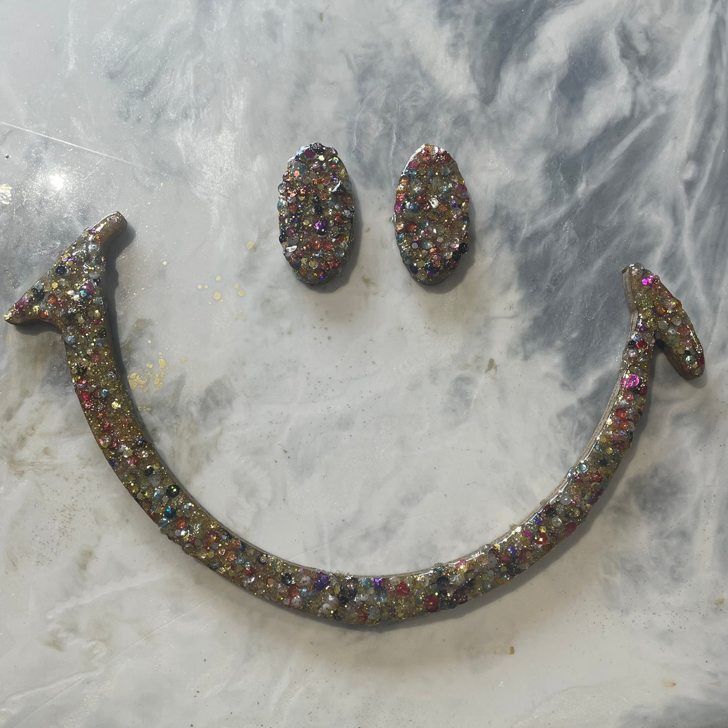 Large gold glitter and sequin eyes and mouth.
