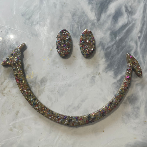 Large gold glitter and sequin eyes and mouth.