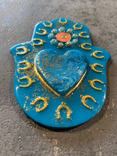 Large Hamsa hand in blue decorated with a resin heart, horseshoes and an evil eye