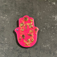 Small neon pink hamsa hand with gold miligros charms.